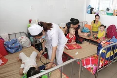 Bác sỹ thăm khám cho bệnh nhân mắc tay chân miệng tại tỉnh Bến Tre. (Ảnh: TTXVN/Vietnam+)