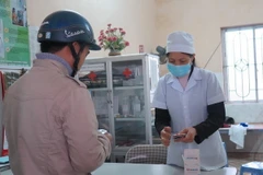 Cấp phát thuốc cho người dân phòng bệnh viên não mô cầu. (Ảnh: TTXVN/Vietnam+)