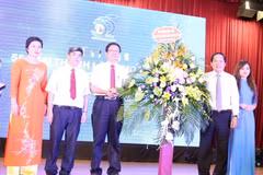 Ông Trương Minh Tuấn, Ủy viên Trung ương Đảng, Bộ trưởng Bộ Thông tin và Truyền thông tặng hoa chúc mừng Khoa Báo chí. (Ảnh: Anh Linh/TTXVN phát)
