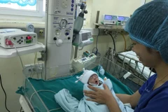 Nhân viên y tế chăm sóc bệnh nhi sau phẫu thuật tim. (Ảnh: PV/Vietnam+)