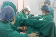 Các bác sỹ thực hiện ca đỡ đẻ cho một sản phụ. (Ảnh: Hương Thu/TTXVN)