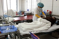 Nhân viên y tế chăm sóc sức khỏe cho bệnh nhân. (Ảnh: Dương Ngọc/TTXVN)