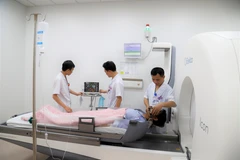 Các bác sỹ Bệnh viện K điều trị xạ phẫu bằng Gamma Knife thế hệ Icon cho một bệnh nhân. (Ảnh: PV/Vietnam+)