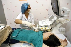 Kỹ thuật hút chân không loại bỏ hoàn toàn tổn thương vú cho bệnh nhân. (Ảnh: Dương Ngọc/TTXVN) 