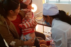 Nhân viên y tế tiêm chủng cho trẻ. (Ảnh: T.G/Vietnam+)