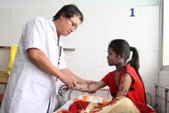 Bác sỹ điều trị cho một bệnh nhân mắc bệnh thủy đậu. (Ảnh: Phương Vy/TTXVN)