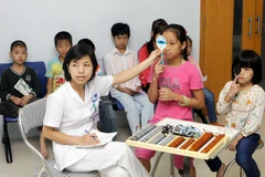 Khám mắt miễn phí cho trẻ em. (Ảnh: TTXVN)