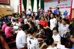 Người dân các dân tộc tỉnh Cao Bằng hào hứng xếp hàng chờ hiến máu. (Ảnh: PV/Vietnam+)