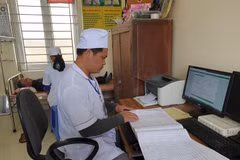Nhân viên y tế kiểm tra sổ sách tại Trạm y tế xã Kim Chính, huyện Kim Sơn, Ninh Bình. (Ảnh: PV/Vietnam+)
