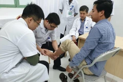 Bác sỹ khám cho bệnh nhân. (Ảnh: PV/Vietnam+)