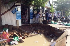 Vệ sinh môi trường nơi nước bị ngập. (Ảnh: Công Thử/TTXVN)