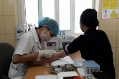 Nhân viên y tế lẫy máu xét nghiệm cho bệnh nhân tại Bệnh viện K. (Ảnh: PV/Vietnam+)