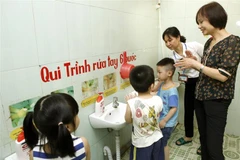 Hướng dẫn học sinh vệ sinh tay phòng chống dịch bệnh. (Ảnh: TTXVN/Vietnam+)