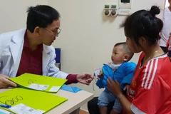 Bác sỹ Bệnh viện Hữu nghị Việt Nam Cu Ba khám cho trẻ em dị tật hàm mặt. (Ảnh: PV/Vietnam+)