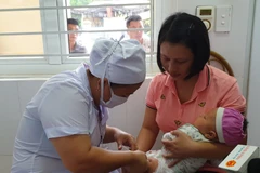 Nhân viên y tế tiêm chủng cho trẻ nhỏ. (Ảnh: T.G/Vietnam+)