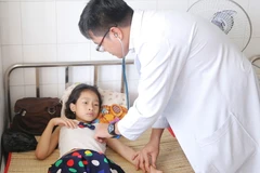 Bác sỹ khám cho bệnh nhân mắc sốt xuất huyết Dengue tại Bệnh viện đa khoa tỉnh Tiền Giang. (Ảnh: Nam Thái/TTXVN)