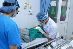 Bác sỹ đang can thiệp cho nữ bệnh nhân. (Ảnh: PV/Vietnam+)