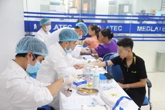Lấy mẫu máu xét nghiệm cho người dân. (Ảnh: PV/Vietnam+)