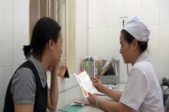 Nhân viên y tế hướng dẫn tư vấn dự phòng lây truyền HIV từ mẹ sang con. (Ảnh: Diệp Anh/TTXVN)