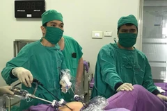 Các bác sỹ phẫu thuật nội soi cho bệnh nhân. (Ảnh: PV/Vietnam+)