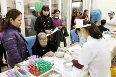 Nhân viên y tế lấy máu xét nghiệm cho người bệnh. (Ảnh: TTXVN/Vietnam+)