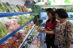 Người dân lựa chọn thực phẩm ở một cửa hàng thực phẩm sạch. (Nguồn: TTXVN)