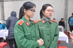 Hoàng Nhã Phương (bên phải) - cô sinh viên năm thứ 4 của Học viện Quân Y, rất vui vẻ và hồ hởi đến viết vào bản đăng ký hiến tạng. (Ảnh: PV/Vietnam+)