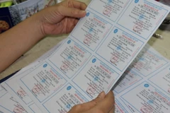kiểm tra thẻ bảo hiểm y tế trước khi phát hành. (Ảnh: PV/Vietnam+)