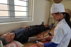 Nhân viên y tế khám bệnh cho người dân tạ Trạm y tế xã Kim Chính, tỉnh Ninh Bình. (Ảnh: T.G/Vietnam+)