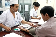 Nhân viên y tế kiểm tra sức khỏe cho bệnh nhân có HIV. (Ảnh: Dương Ngọc/TTXVN)