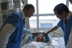 Giáo sư Nguyễn Thanh Liêm thăm khám cho một bệnh nhân sau phẫu thuật. (Ảnh: PV/Vietnam+)