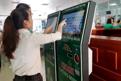 Người dân làm thủ tục với thẻ khám bệnh thông minh. (Ảnh: PV/Vietnam+)