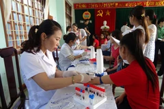 Nhân viên y tế khám sức khỏe cho người dân. (Ảnh: TTXVN/Vietnam+)