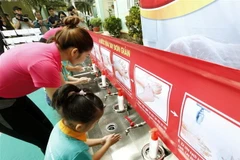 Hướng dẫn cho trẻ rửa tay với xà phòng để phòng chống dịch bệnh. (Ảnh: TTXVN/Vietnam+)