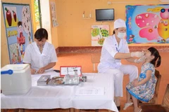 Nhân viên y tế cho trẻ uông vắcxin phòng bại liệt tại vùng nguy cơ cao. (Ảnh: PV/Vietnam+)