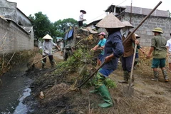 Người dân thu gom rác thải, đảm bảo vệ sinh môi trường. (Ảnh: TTXVN/Vietnam+)