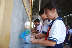 Học sinh rửa tay trước khi vào lớp học. (Ảnh: Huỳnh Phúc Hậu/TTXVN)