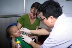 Bác sỹ Bệnh viện Hữu nghị Việt Nam Cu Ba khám cho trẻ bị sứt môi. (Ảnh: PV/Vietnam+)