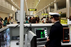  Nhân viên Trung tâm Kiểm dịch Y tế quốc tế kiểm tra thân nhiệt và kê tờ khai y tế cho hành khách. (Ảnh: Dương Ngọc/TTXVN)