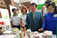 Bộ trưởng Bộ Y tế và Bộ trưởng Bộ tài nguyên và Môi trường tham quan các gian hàng thân thiện với môi trường. (Ảnh: T.G/vietnam+)