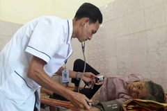 Nhân viên y tế khám sức khỏe cho người dân tại Trạm y tế xã Đồng Thịnh. (Ảnh: Thùy Giang/Vietnam+)