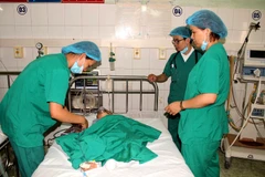 Các y, bác sỹ thực hiện phẫu thuật cho các trẻ em bị khuyết tật. (Ảnh: Văn Tý/TTXVN)