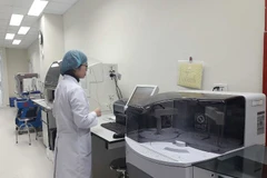 Nhân viên y tế vận hành máy móc tại Phòng xét nghiệm tham chiếu về kháng kháng sinh. (Ảnh: PV/Vietnam+)