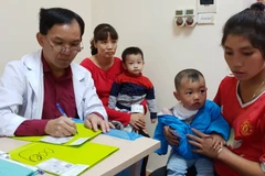 Bác sỹ Bệnh viện Hữu nghị Việt Nam Cu Ba khám cho trẻ em dị tật hàm mặt. (Ảnh: PV/Vietnam+)