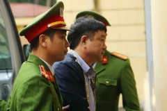 Cảnh sát dẫn giải bị cáo Đinh La Thăng vào phòng xét xử. (Ảnh: Doãn Tấn/TTXVN)