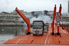 Nhiều phương tiện chở hàng hóa được thông quan qua lối mở cầu phao Hải Yên. (Ảnh: Văn Đức/TTXVN)