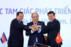 Ba Thủ tướng Campuchia-Lào-Việt Nam thể hiện tinh thần đoàn kết và hợp tác ba nước sau khi ký kết Tuyên bố chung Hội nghị Cấp cao hợp tác Khu vực Tam giác phát triển Campuchia-Lào-Việt Nam (CLV) lần thứ 10. (Ảnh: TTXVN)