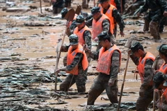 Lực lượng cứu hộ tìm kiếm nạn nhân và khắc phục hậu quả mưa lũ. (Ảnh: THX/TTXVN)