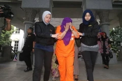 Cảnh sát áp giải cựu Cục trưởng Cục tình báo nước ngoài Malaysia Hasanah Abdul Hamid (giữa) tới tòa án Putrajaya Magistrate. (Ảnh: NST/TTXVN)