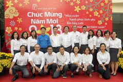 Ông Võ Văn Thưởng chụp ảnh chung với cán bộ, công nhân viên Nhà xuất bản Trẻ. (Ảnh: Quang Nhựt/TTXVN)